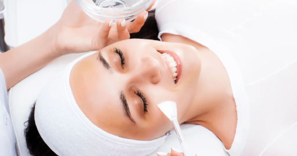 Current image: Professional applying a Chemical Peel solution to a woman's skin, representing Chemical Peel in Lakewood CO for clearer, smoother skin.